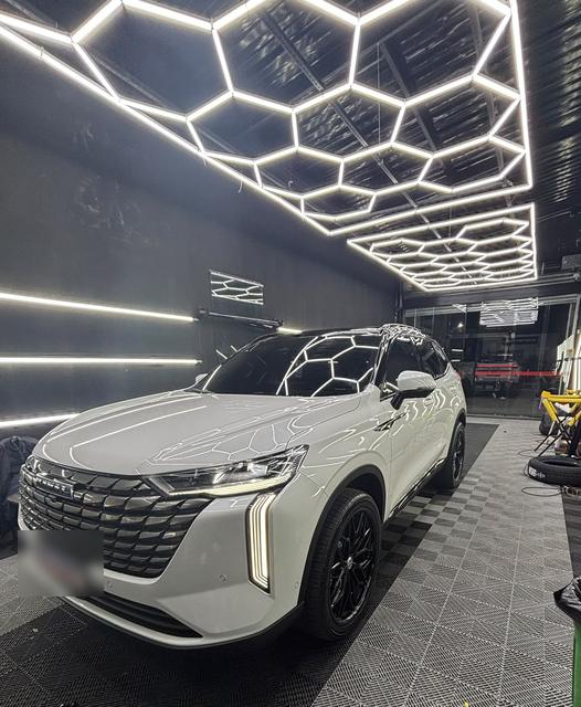 SUV branco sob a iluminação hexagonal da loja
